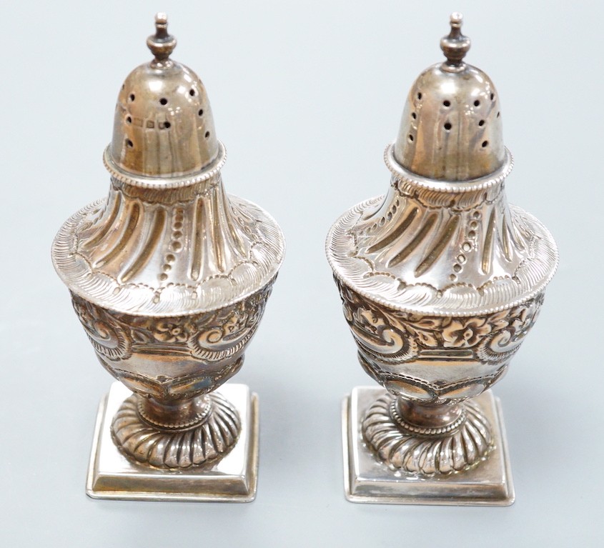 A pair of late Victorian silver vase shaped pedestal pepperettes, by Josiah Williams & Co, London, 1897, 10.5cm, 120 grams.